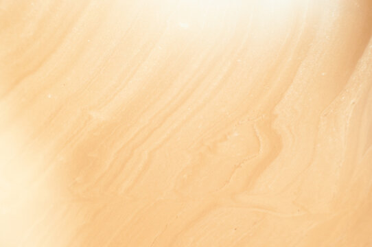 Sand dunes in the desert with swirling patterns at sunset