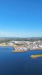 Obraz premium Wide distant view of Inverness, Scotland, British Highlands, revealing the river, green lands, sea edge, and cloudy daytime scenery.