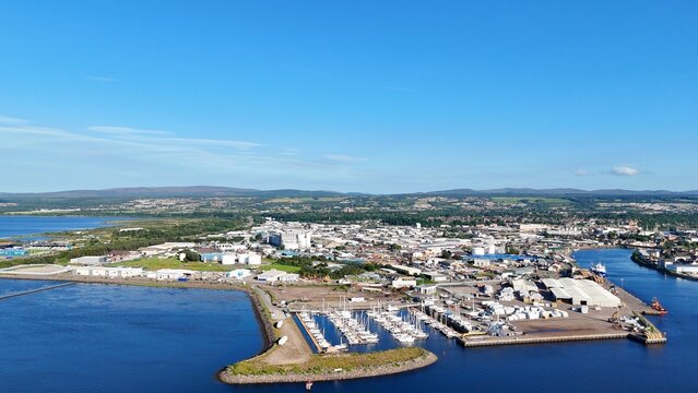 A far panoramic view of Inverness, Scotland, British Highlands, with the river winding through lands toward the sea under clouds.