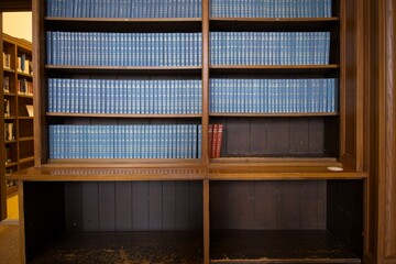 Wooden library shelves with blue hardcover books
