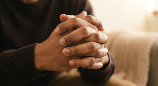 Hands clasped together, a thoughtful posture.
