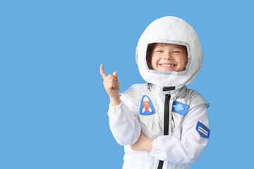Smiling young boy in astronaut costume pointing up with finger, space exploration and childhood dreams concept, the childs happy expression conveys imagination and future career aspirations © Pixel-Shot