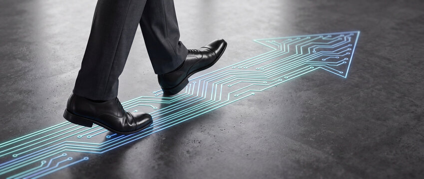Businessman stepping on digital circuit path illuminated by glowing blue neon light on a dark concrete floor, representing corporate innovation, career growth, and technological progress