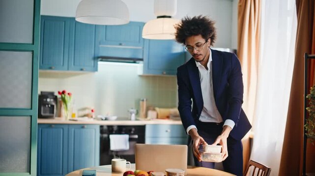 Businessman packing briefcase morning kitchen. Man preparing work lunch home.