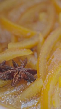 Orange peel strips boil in syrup with star anise. Concept of homemade candied orange peel and spiced citrus flavor
