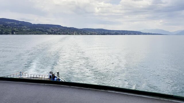 Lake Landscape With Boat Wake and Distant Hills Seen From a Ferry in Switzerland