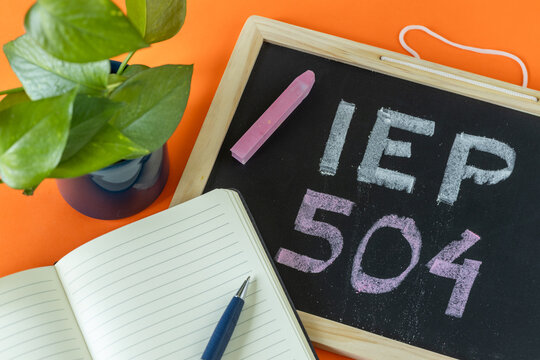 IEP 504 Handwritten in chalk on a school blackboard, Individual education plan, Business concept, IEP 504 program, copy space, Text on natural wooden blocks