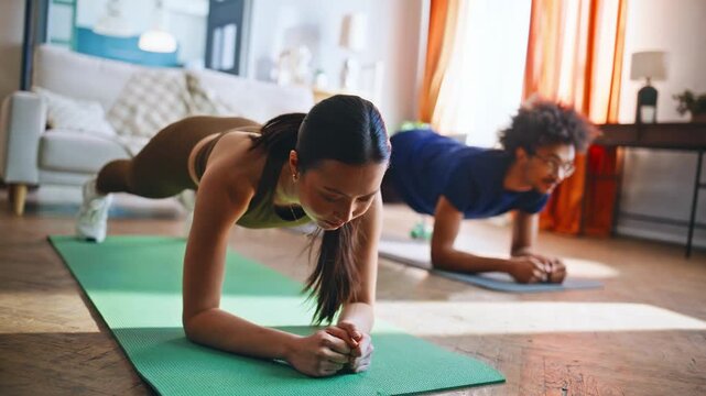 Multiethnic couple holding plank position home workout. Fitness training.