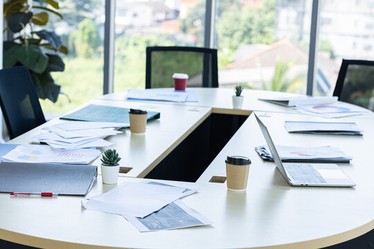 laptop, smartphone, and work files are placed office supplies on the desk background in meeting room office workspace