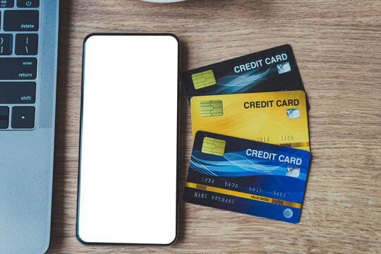 Credit card of laptop computer, smartphone empty screen and coffee cup on wooden background,Online banking Concept