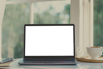 Fototapeta premium Mockup of laptop computer with empty screen with notebook,coffee cup and smartphone on table of the Wooden wall background at the cafe,White screen