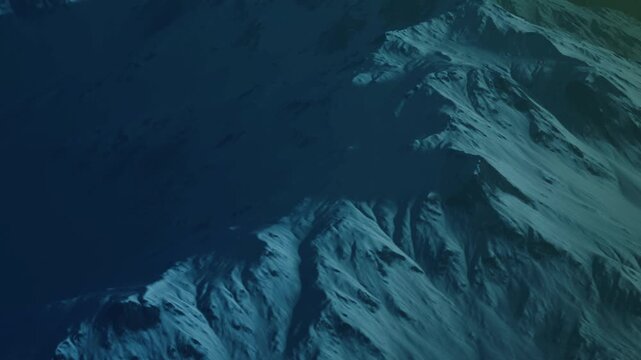 Snow covers the mountain peaks in a dark scene. The sky shows hints of light. Shadows stretch across the rugged terrain. This is a nighttime view of a winter landscape.