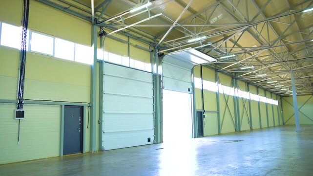 Empty Warehouse Interior With Open Loading Door and Steel Support Columns