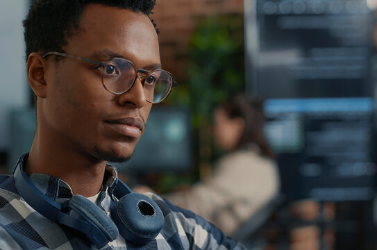 Software Engineer Fixing Glasses While Coding at a software development desk after compiling source code successfully, showing algorithm work and coding success.