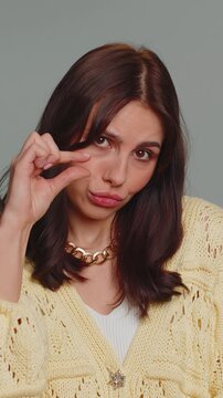 Give me money, please. Woman rubbing fingers show cash gesture, demands to pay back the debt, take loan, do shopping, begging, investment, reward. Young girl isolated on gray studio background