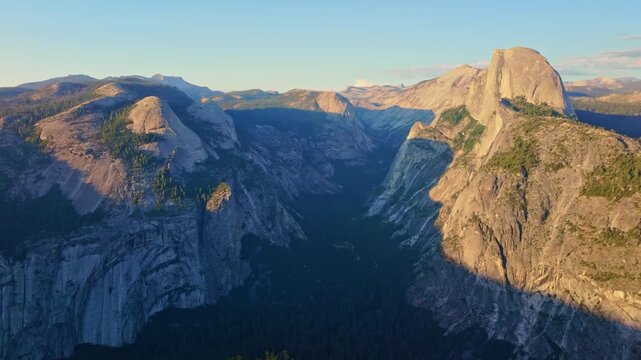 Golden sunset light bathes Half Dome as seen from Glacier Point in Yosemite
