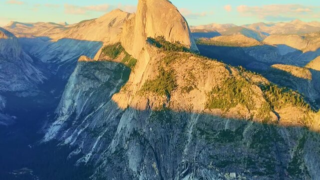 Golden sunset light bathes Half Dome as seen from Glacier Point in Yosemite
