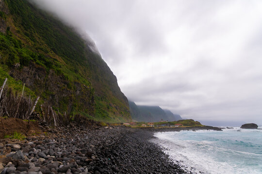 Dramatic coastline with black pebble beach and cliffs
