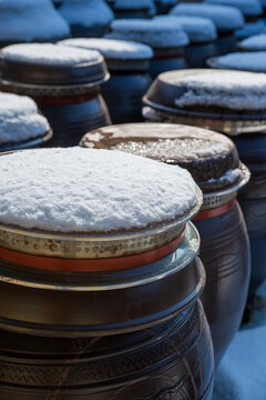 Snow covered traditional korean earthenware jars onggi in south korea temple.