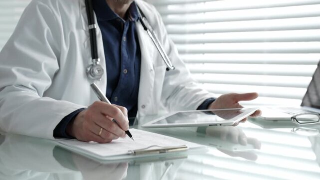 Doctor taking notes on a clipboard and holding a digital tablet, combining traditional paperwork with modern technology in healthcare for patient record management and medical consultation