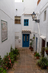 Fototapeta premium Charming White Alley with Blue Door in Mediterranean Village