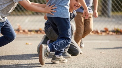 Obraz premium Group of diverse young boys playing tag and running together on an outdoor school playground, representing childhood friendship, active lifestyle, and energetic recreation