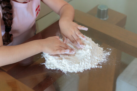 manos de ni&ntilde;a formando un volc&aacute;n de harina para preparar pasta casera