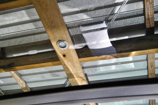 Wooden beams and metal roof structure with glass panel and light fixture