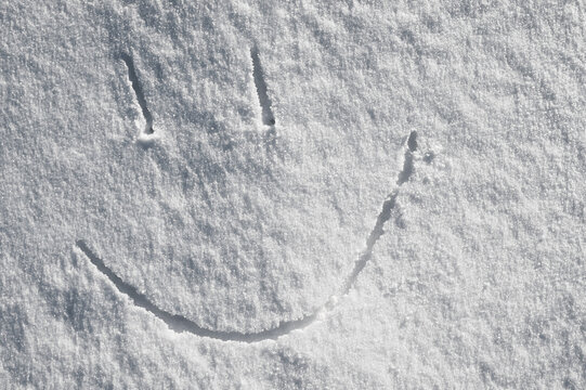 Snowy background, the photo shows the texture of snow in winter and lines with strokes reminiscent of a smile