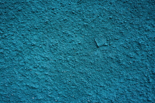 Blue textured concrete wall with a rough plaster surface, perfect as an abstract background for creative design and architectural projects.