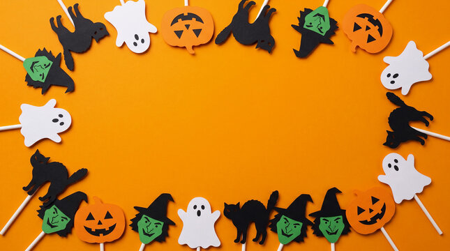 Halloween orange background with ghost, cat, witch and pumpkin lollipop paper cut out border frame, spooky copy space for party invitation, greeting card and autumn design