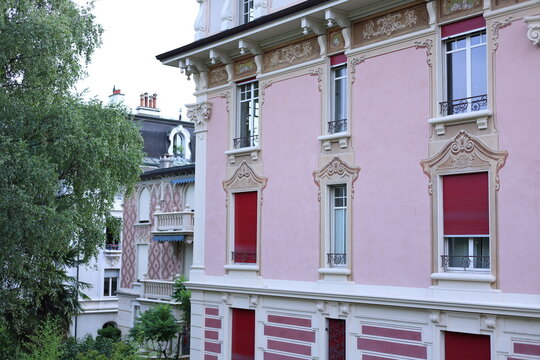 Fa&ccedil;ade rose orn&eacute;e avec fen&ecirc;tres et volets rouges