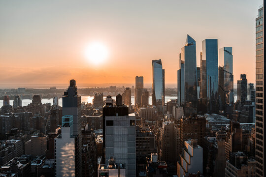 View of mid-town Hudson Yards from an aerial perspective during sunset with the Hudson River behind.