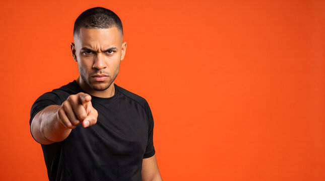 Man pointing finger directly at viewer with intense expression.