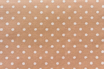 Tan polka dot fabric, flat lay © angintaravichian