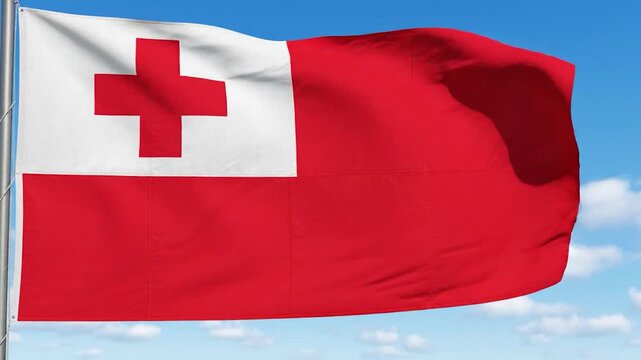The national flag of Tonga waving against a bright blue sky