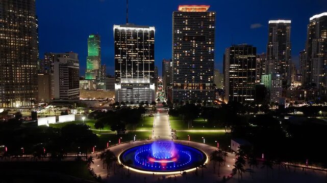 Downtown Miami skyline with illuminated skyscrapers and Bayfront Park fountain at blue hour, Florida, USA. g.