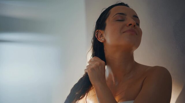 Woman washing long hair shower closeup. Relaxed lady enjoying spa bathing.