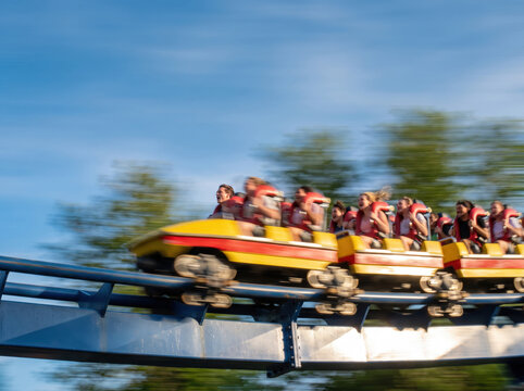 People riding a fast roller coaster at an amusement park