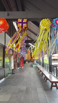 SI RACHA, THAILAND - JULY 19, 2026: Colorful handmade ribbon decorations hanging inside a covered corridor