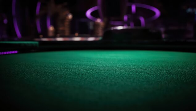 A soft-focus image of a green felt roulette table in a dimly lit casino with purple hues.