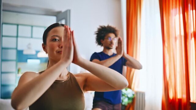 Couple practicing yoga at home. Closeup of woman in tree pose with partner