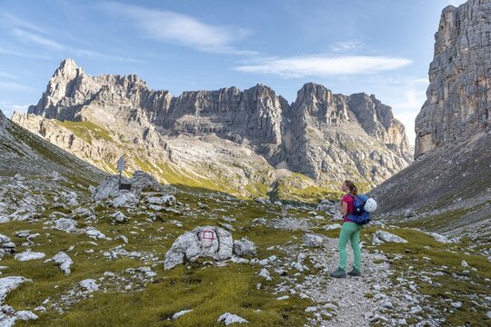 Young hiker on a hiking trail, Sorapiss Circumambulation, behind ridge, Mount Punte Tre Sorelle, Dolomites, Belluno, Italy