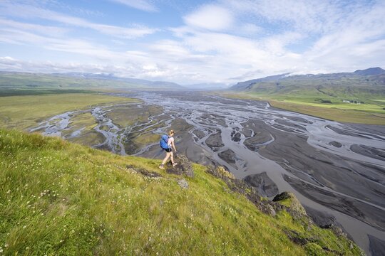 Hiker, Young woman on a hill, view over alluvial land, meandering river, D&iacute;monarhellir, Su&eth;urland, Iceland
