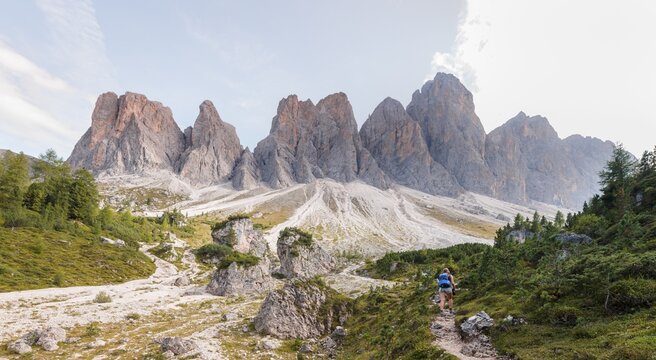 Hiking on footpath to the Geisleralm in the Villn&ouml;s valley below the Geisler Peaks, behind the Geisler Group, Sass Rigais, Dolomites, South Tyrol, Italy