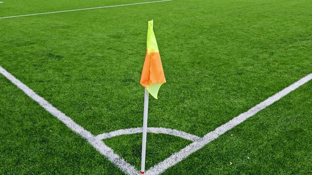 Football field corner with an orange corner flag