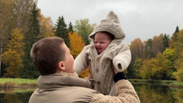 father and child playing joyfully in an autumnal park with jackets and a hat, side view medium shot, brown, green, yellow, gray, family moments, parent-child interaction, commercial, nature.