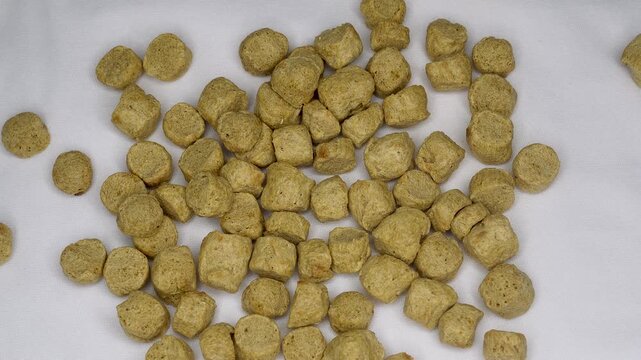 Top view of stack dry raw soya chunks on white background. Healthy protein rich nutritious soybean meat. Vegetarian food concept.