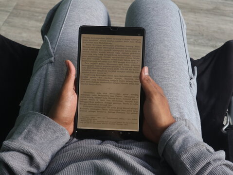 Person reading on a tablet while relaxing