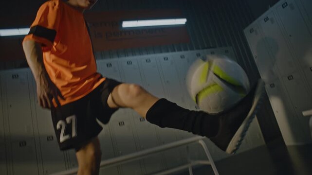Teenage Soccer Player Practicing indoor Football Tricks. Young Man Methodically Juggling Balls, Demonstrating Quick Reflexes, Precision Footwork Next to Changing Room Benches. Motivational in Sports.